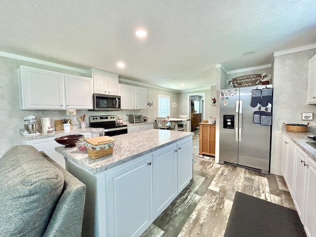 kitchen featuring crown molding, white cabinetry, light wood finished floors, and stainless steel appliances