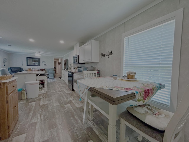 dining space with ornamental molding, recessed lighting, and light wood-style flooring