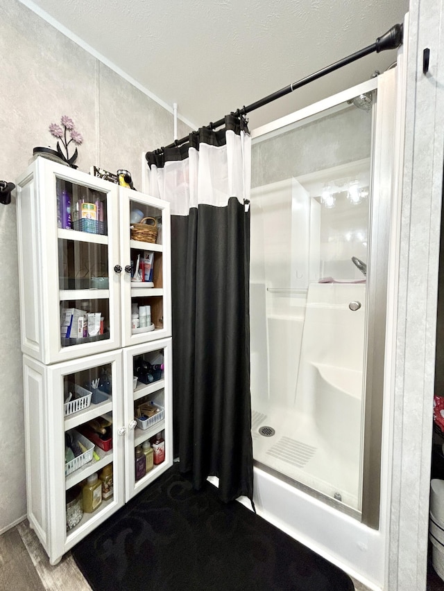 bathroom featuring a shower stall and wood finished floors