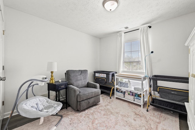 living area featuring visible vents and a textured ceiling