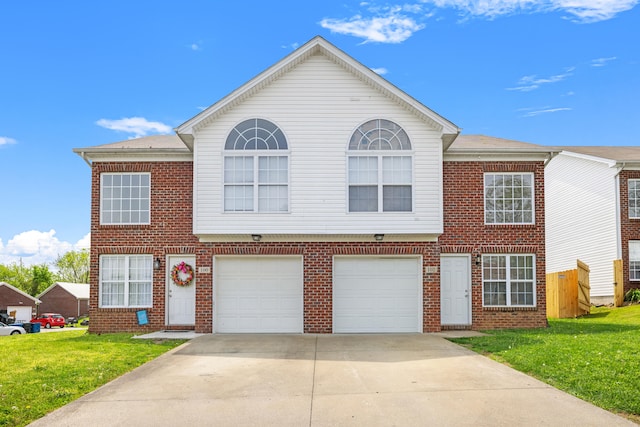 view of property with an attached garage, concrete driveway, a front lawn, and brick siding