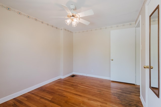 spare room featuring ceiling fan, baseboards, and wood finished floors