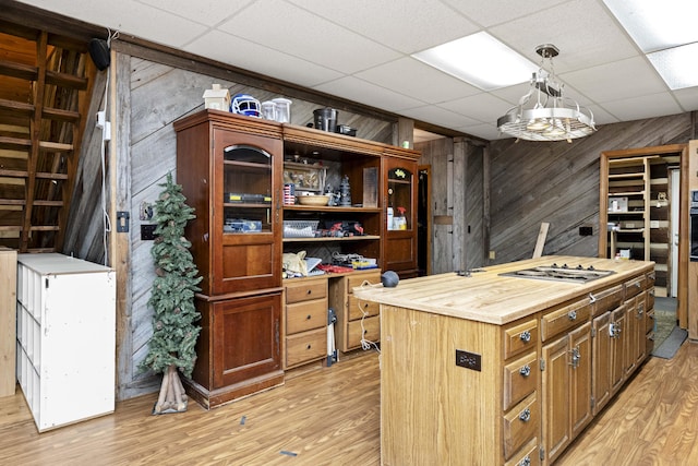 2616 Doylesville Rd, Richmond, KY 40475 - interior space with a kitchen island, stainless steel stovetop, wooden walls, a drop ceiling, and light wood-style flooring