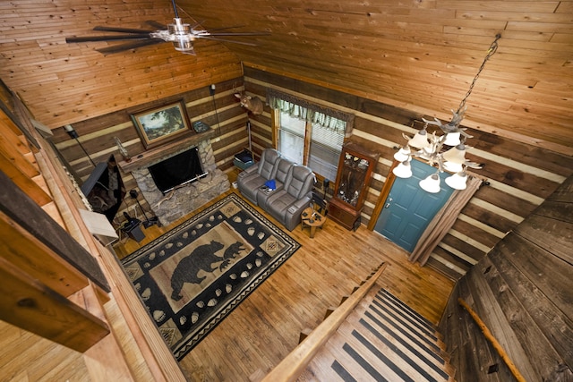 2616 Doylesville Rd, Richmond, KY 40475 - living room with a fireplace, wood walls, wood finished floors, ceiling fan with notable chandelier, and lofted ceiling