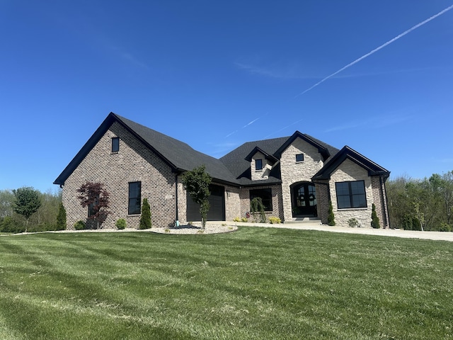 french country inspired facade with an attached garage, brick siding, a front yard, and stone siding