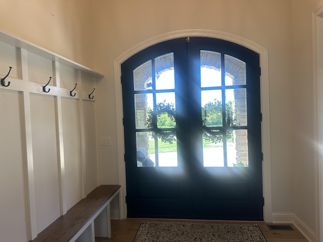 mudroom with arched walkways, visible vents, plenty of natural light, and light wood finished floors