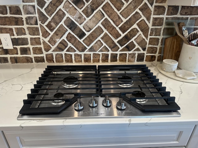 details with stainless steel gas cooktop and light stone counters