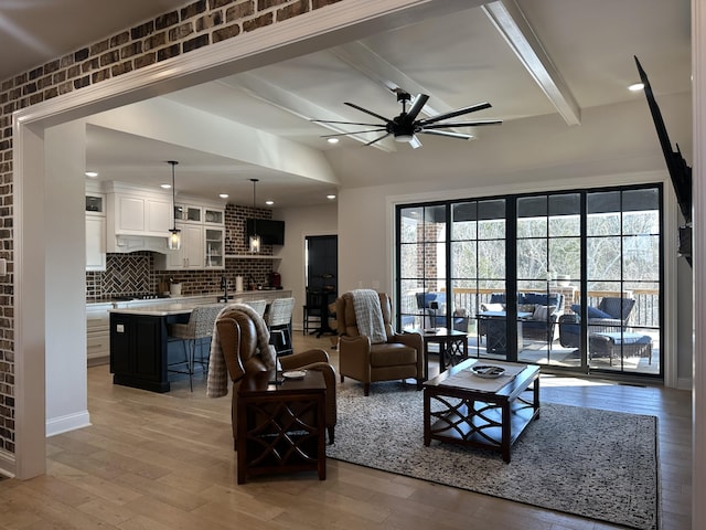 living area featuring vaulted ceiling with beams, a ceiling fan, light wood-style flooring, and recessed lighting