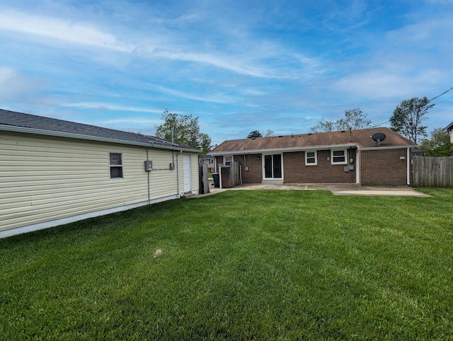 rear view of house featuring a yard, a patio, and fence