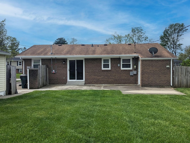 rear view of property with fence, a lawn, a patio area, and brick siding