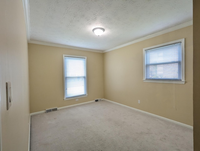 carpeted empty room featuring visible vents, ornamental molding, and a textured ceiling