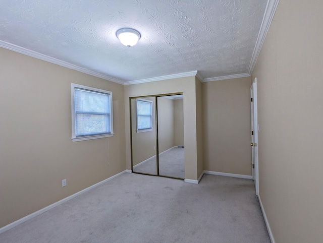 unfurnished bedroom with carpet flooring, crown molding, a textured ceiling, baseboards, and a closet