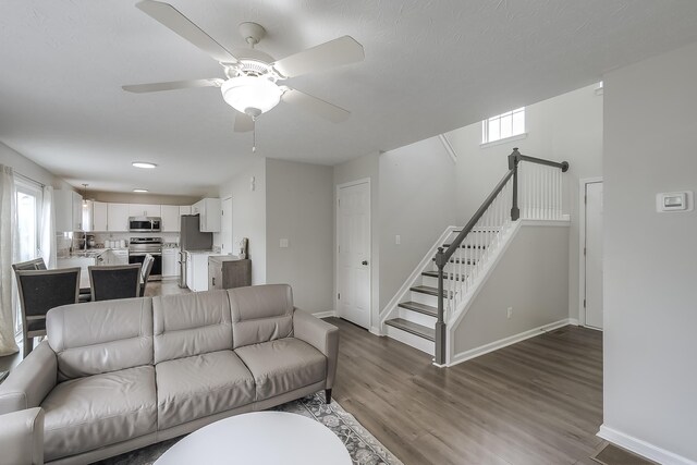 132 Mason Springs Dr, Nicholasville, KY 40356 - living room featuring wood finished floors, baseboards, a ceiling fan, and stairway
