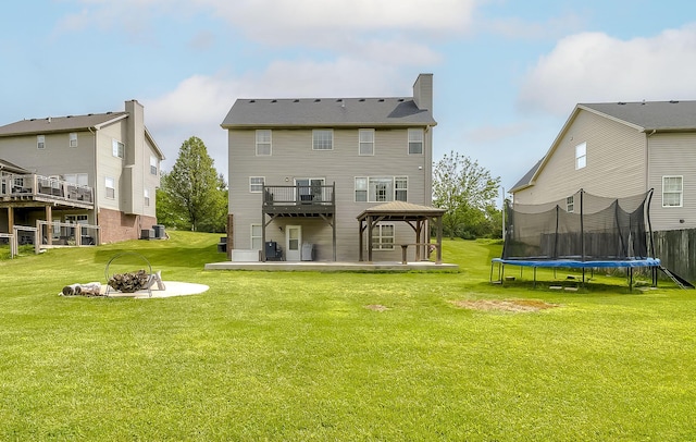 132 Mason Springs Dr, Nicholasville, KY 40356 - rear view of property with a gazebo, a trampoline, an outdoor fire pit, a patio area, and a lawn