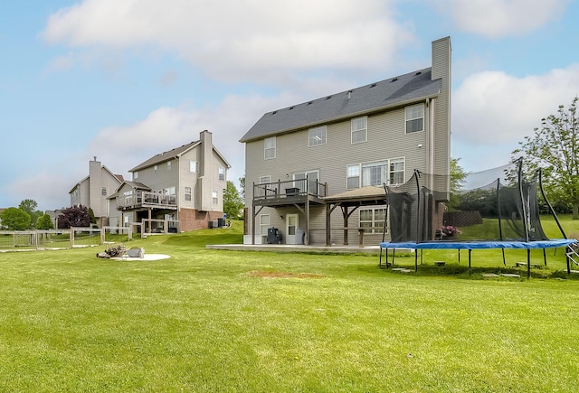 132 Mason Springs Dr, Nicholasville, KY 40356 - back of property featuring a trampoline, a wooden deck, a chimney, and a patio area