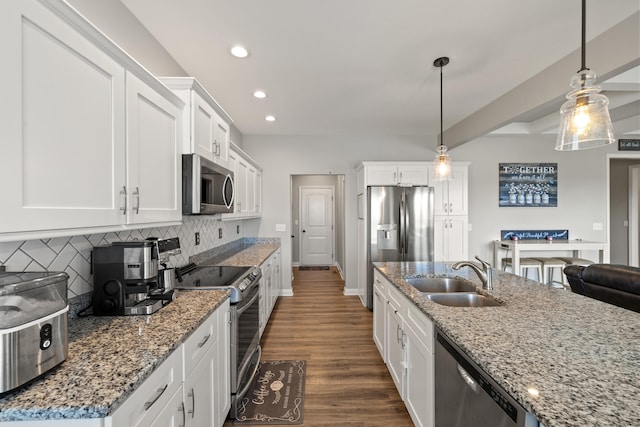 kitchen with appliances with stainless steel finishes, a sink, white cabinetry, recessed lighting, and decorative backsplash