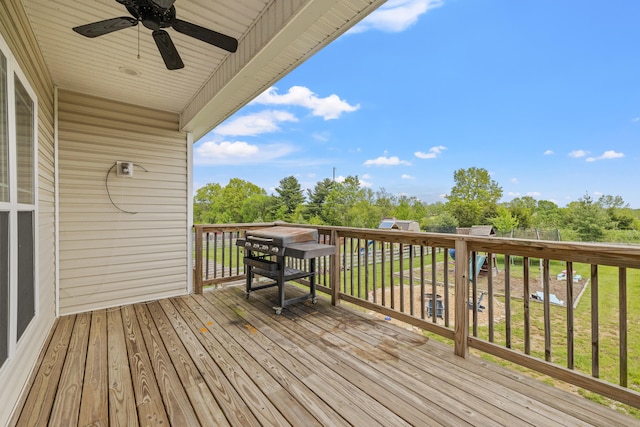 wooden deck with a lawn and a ceiling fan