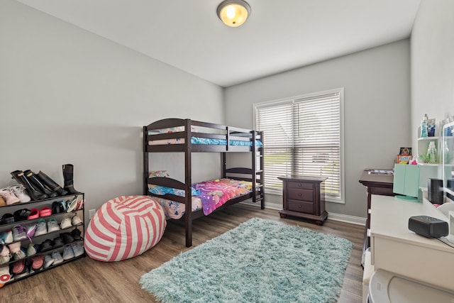 bedroom with baseboards and wood finished floors