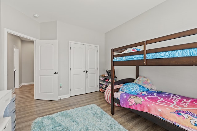 bedroom with a closet, baseboards, and wood finished floors