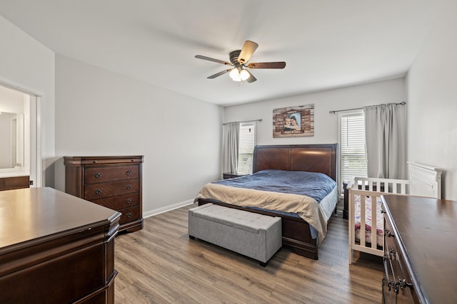 bedroom featuring baseboards, multiple windows, and wood finished floors