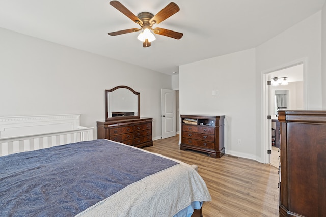 bedroom with a ceiling fan, baseboards, and wood finished floors