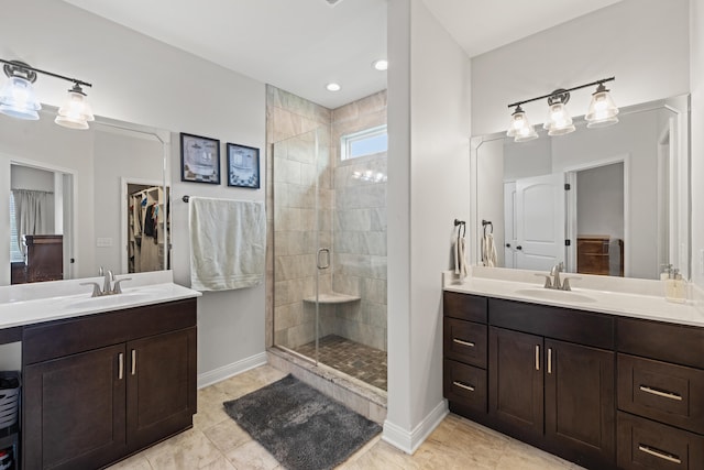 full bath featuring two vanities, a sink, and a stall shower