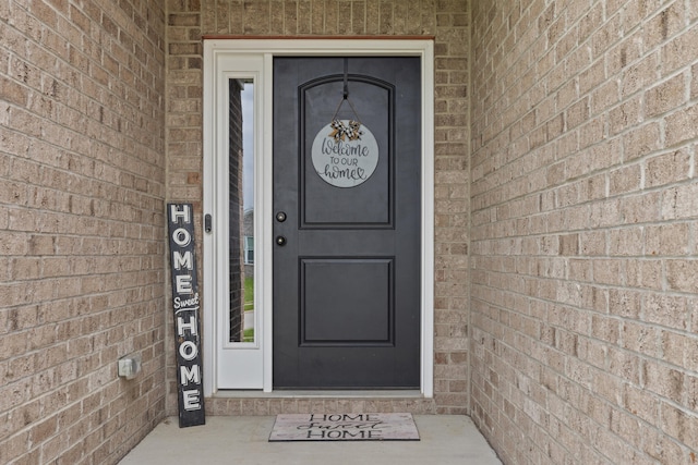 view of exterior entry featuring brick siding