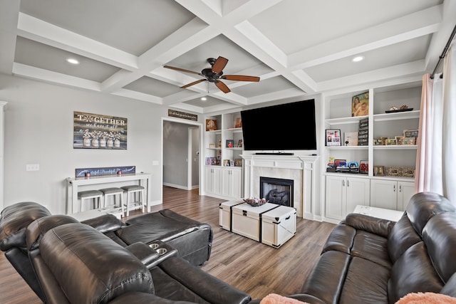 living area featuring baseboards, ceiling fan, wood finished floors, and a fireplace