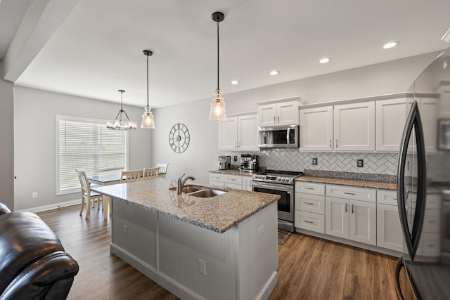 kitchen featuring dark wood-style floors, white cabinetry, tasteful backsplash, a sink, and stainless steel appliances
