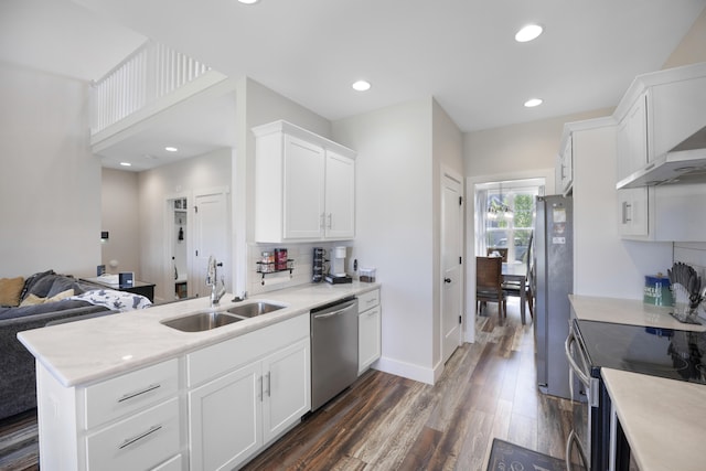 kitchen with a sink, light countertops, stainless steel appliances, white cabinetry, and dark wood-style floors
