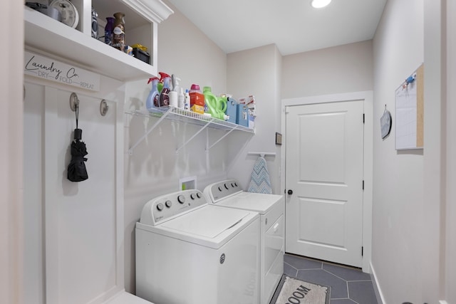 laundry room featuring dark tile patterned flooring, laundry area, baseboards, and washer and clothes dryer