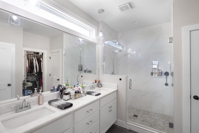 full bath featuring visible vents, a sink, a stall shower, and a spacious closet
