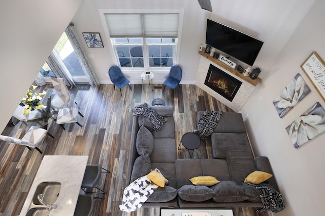 living area with baseboards and wood finished floors