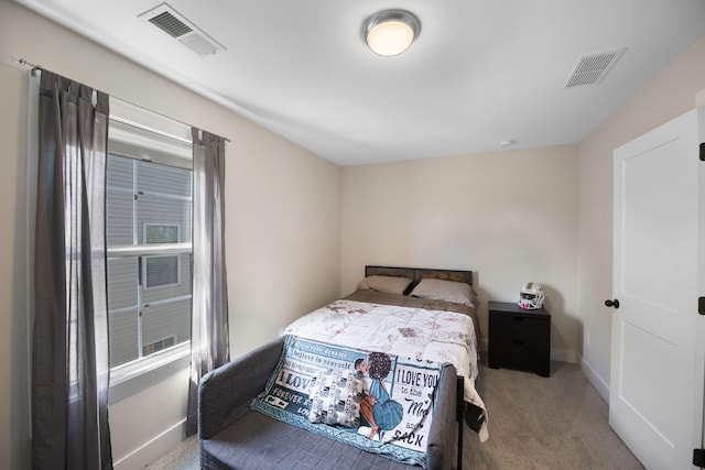 carpeted bedroom featuring baseboards and visible vents