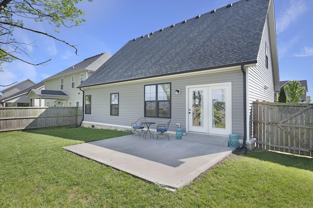 rear view of property with roof with shingles, a patio, a lawn, and a fenced backyard