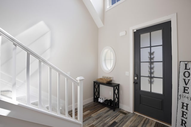 foyer with baseboards, dark wood-style flooring, a high ceiling, and stairway