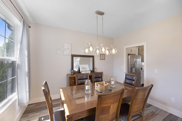 dining room with an inviting chandelier, baseboards, and wood finished floors