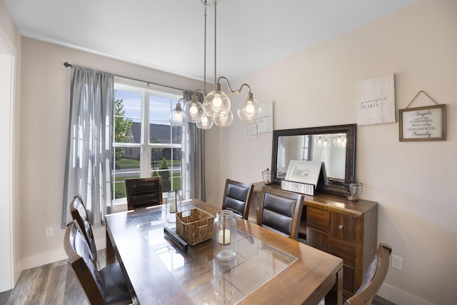 dining area featuring baseboards, a notable chandelier, and wood finished floors