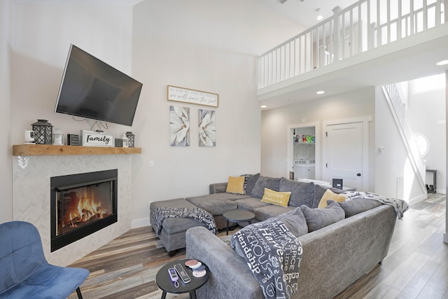 living room with washer / clothes dryer, wood finished floors, and a towering ceiling