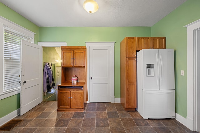 123 Baughman Ave, Danville, KY 40422 - kitchen featuring baseboards, brown cabinets, white refrigerator with ice dispenser, and visible vents