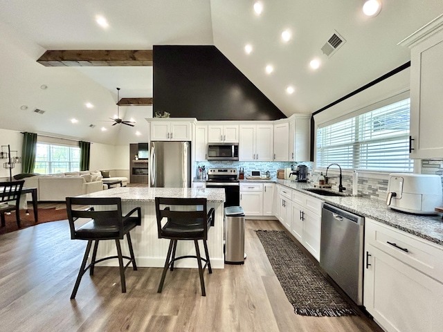 11 Marco Island Dr, Somerset, KY 42503 - kitchen with stainless steel appliances, a sink, a kitchen island, tasteful backsplash, and light stone countertops