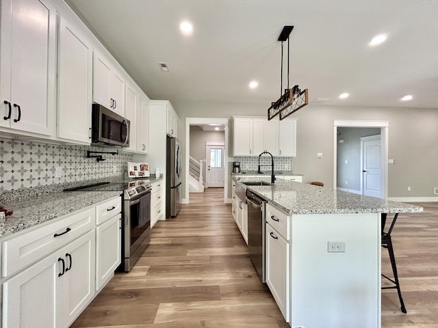108 Patriot Dr, Science Hill, KY 42553 - kitchen featuring stainless steel appliances, a sink, a kitchen bar, recessed lighting, and tasteful backsplash