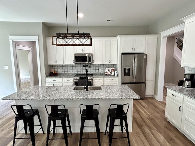108 Patriot Dr, Science Hill, KY 42553 - kitchen featuring stainless steel appliances, a sink, a kitchen breakfast bar, and white cabinets