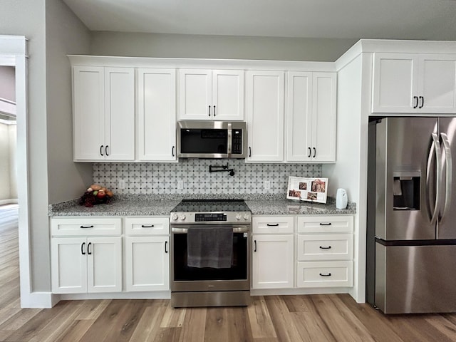 108 Patriot Dr, Science Hill, KY 42553 - kitchen with stainless steel appliances, light wood finished floors, white cabinetry, light stone countertops, and decorative backsplash