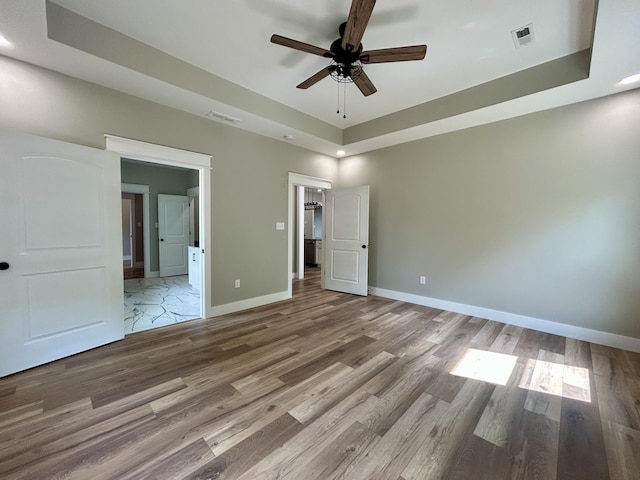 108 Patriot Dr, Science Hill, KY 42553 - unfurnished bedroom with a tray ceiling, wood finished floors, baseboards, recessed lighting, and ensuite bath