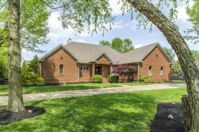 single story home featuring brick siding, a front yard, and a chimney