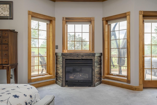 bedroom featuring a stone fireplace and carpet