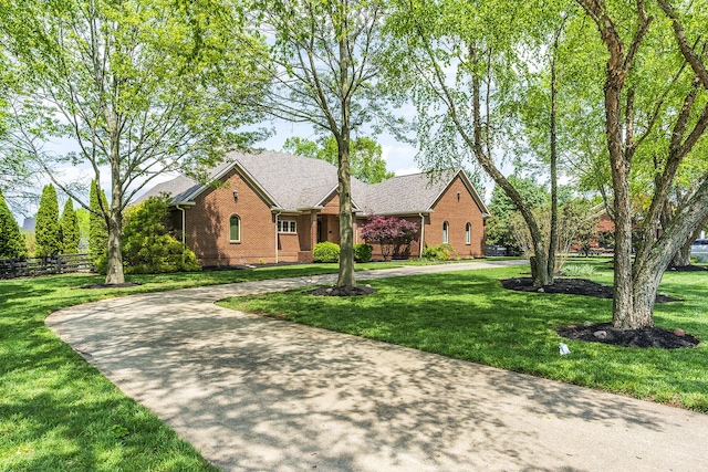 view of front facade with brick siding, a front lawn, and curved driveway