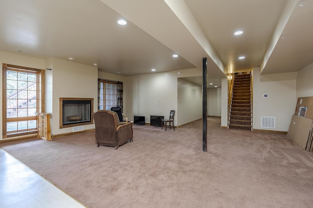 interior space with carpet flooring, visible vents, stairway, and a fireplace