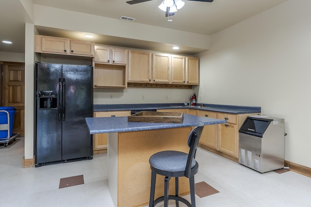 kitchen with ceiling fan, light brown cabinets, a kitchen island, visible vents, and black fridge with ice dispenser